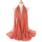 Coral-colored scarf on a mannequin with a white background