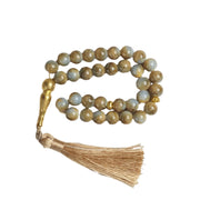 Beaded necklace with tassel on a light gray background