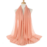 Peach-colored scarf on a mannequin with a white background